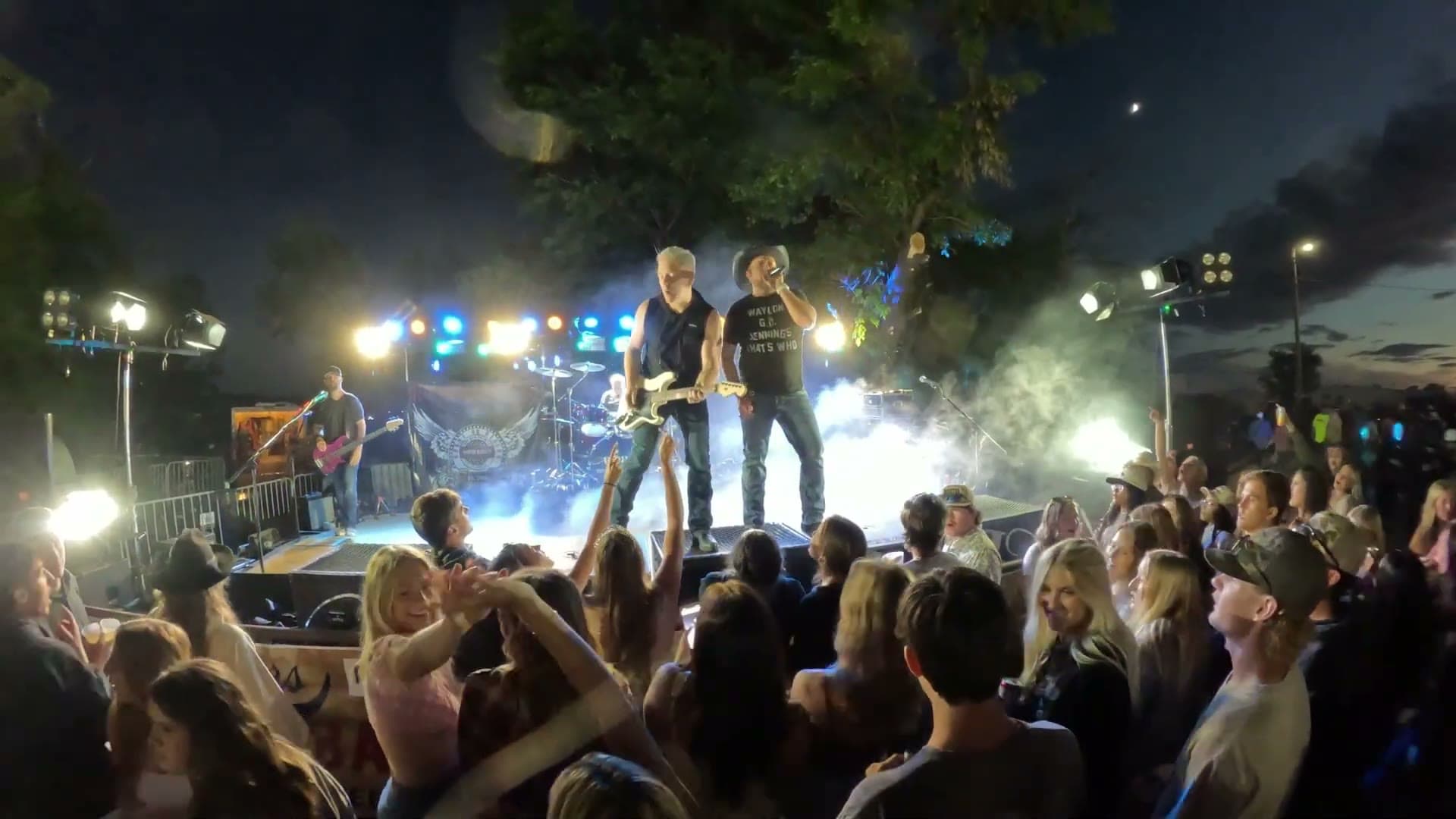 Rhyme Or Reason on stage under blue lights and haze at an outdoor street dance